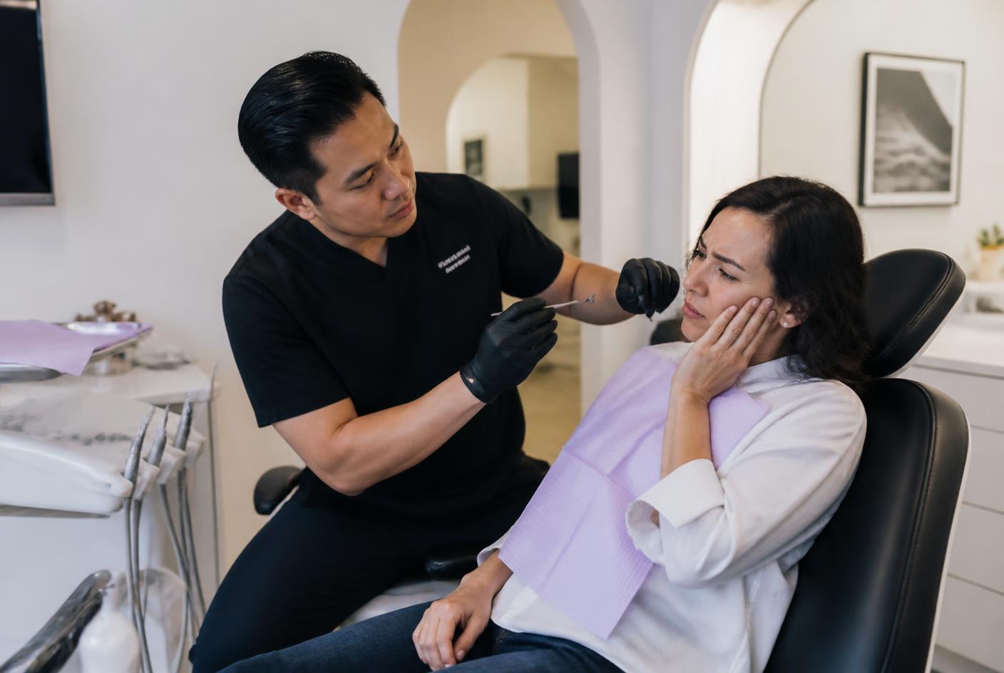 Dentist reassuring a patient attending with dental pain